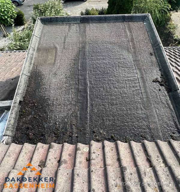 Verouderd plat dak met bitumen en slijtage voor lekkage inspectie in Sassenheim
