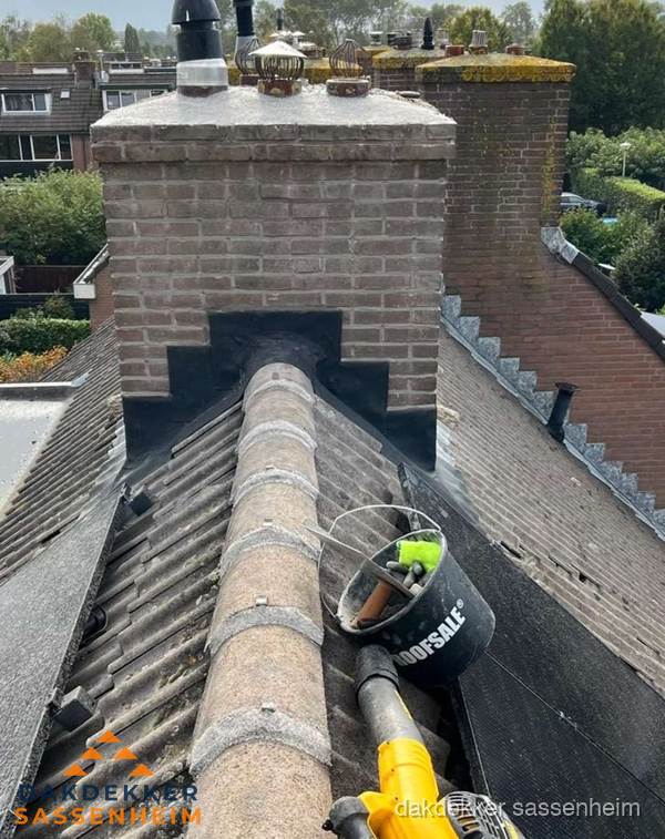 Schoorsteen met loodaansluiting en nokvorst op pannendak in Sassenheim