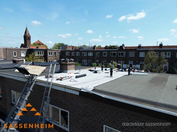 Dakdekkers aan het werk op plat dak in Sassenheim