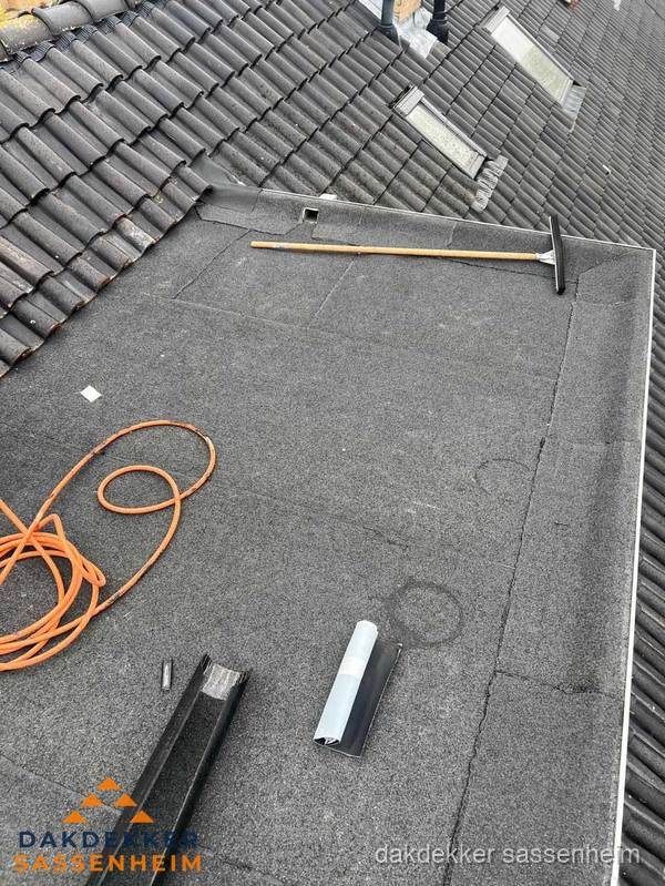 Plat dak reparatie met gereedschap en loodstroken in Sassenheim
