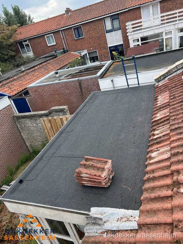 Plat dak aanbouw met bitumen naast schuin pannendak in Sassenheim